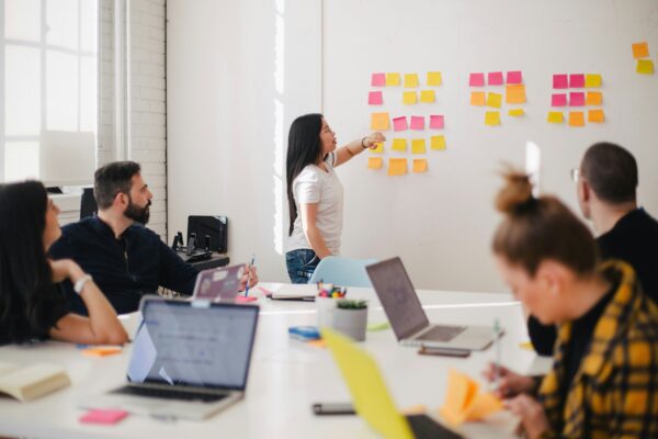 Persone in riunione alla scrivania per mostrare il contesto delle lunghe ore trascorse al computer.